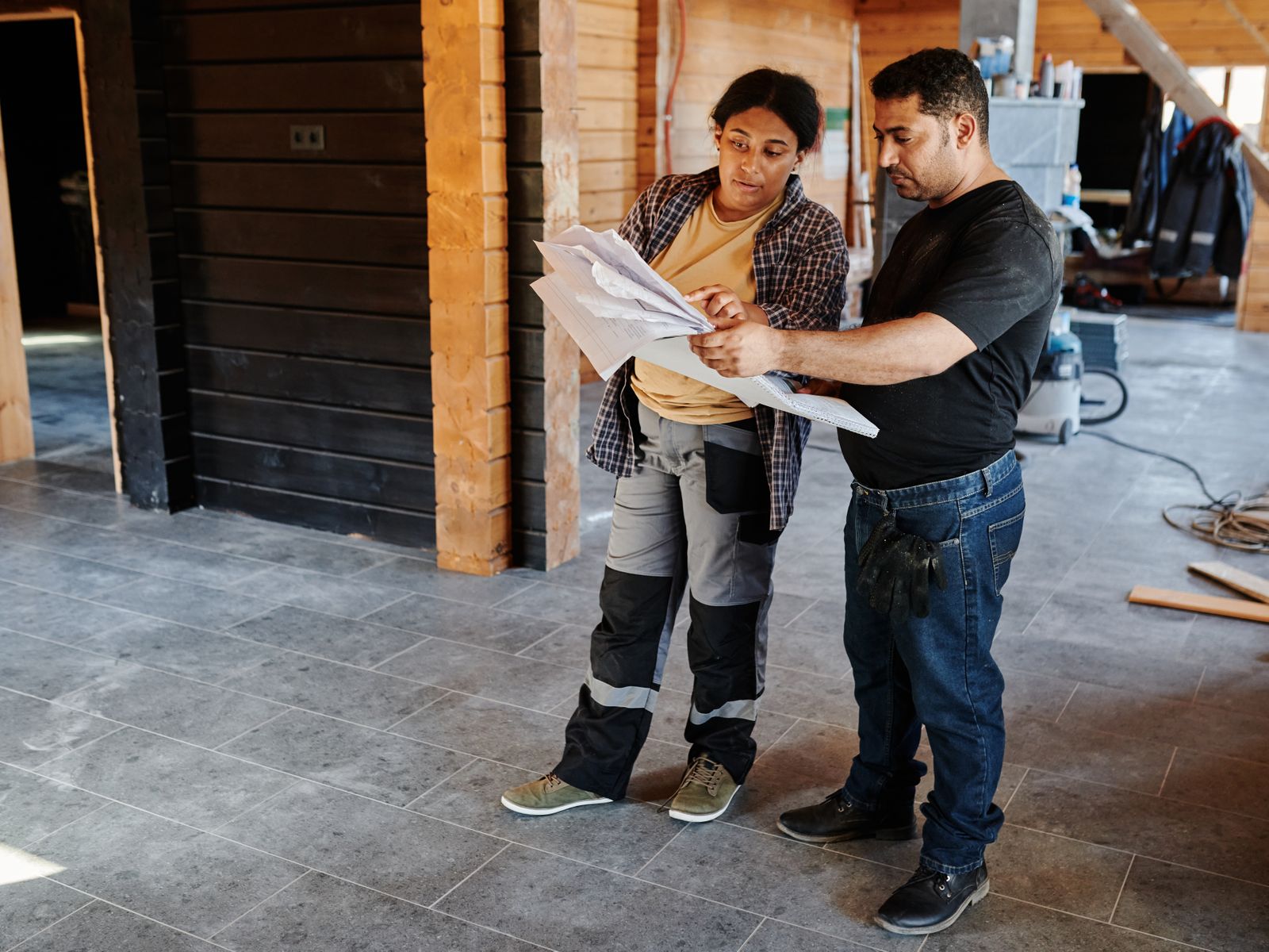 Two Khella superintendents reviewing drawings inside a framed structure