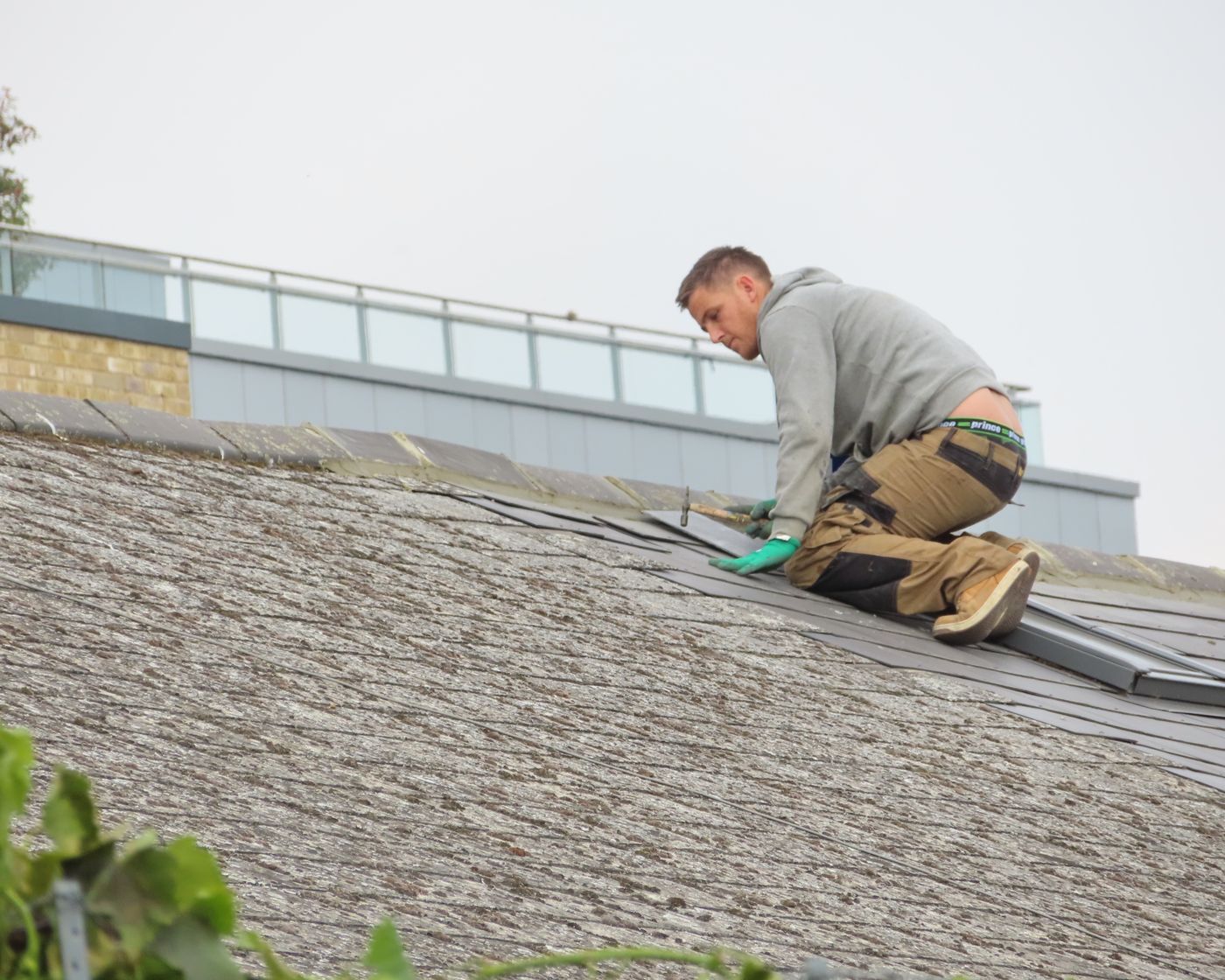 Roofer installing shingles on a residential roof